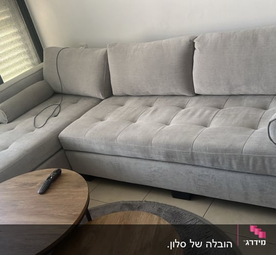 ספה אפורה ליד שולחן עגול בחדר מגורים